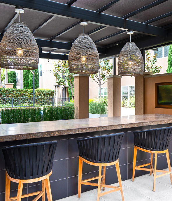 luxury outdoor bar with stone countertops woven basket light covers and woven black barstools