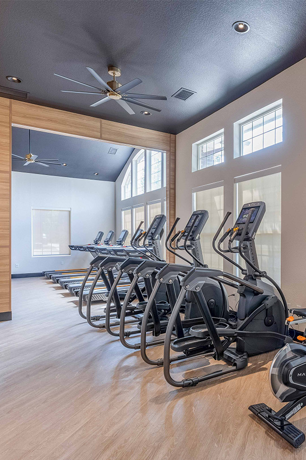 IMT Dayton Station - fitness center with cardio machines and hardwood floors
