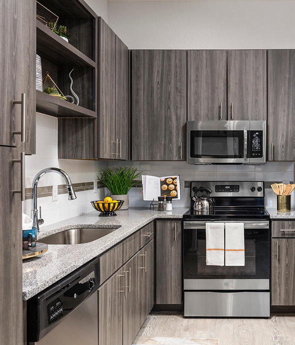 Kitchen with tile floor, dark wood cabinets, stone counters, and stainless steel appliances.