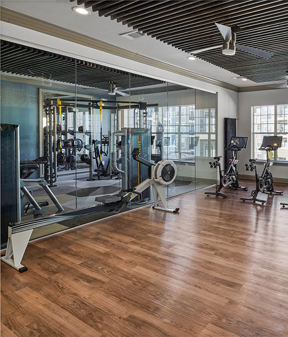 Spin room with mirror walls, spin bikes, and rowing machine.