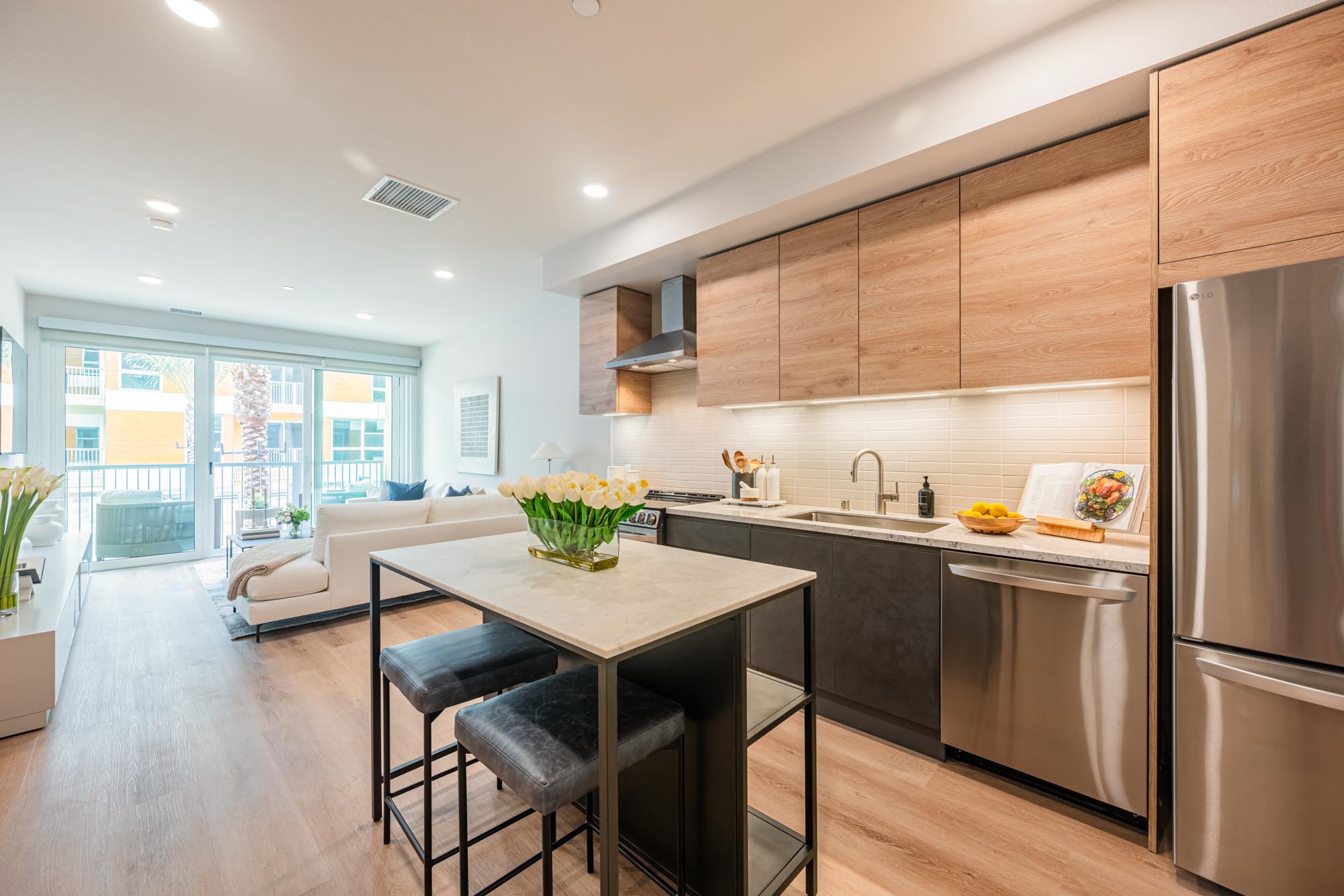 Bright, open-concept kitchen and living space with stainless-steel appliances in a Citrus Commons apartment, Sherman Oaks, Los Angeles, California.