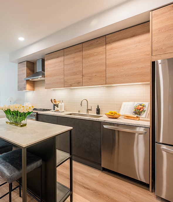Italian oak-style cabinetry with under-cabinet lighting with stainless steel appliances at Citrus Commons, Sherman Oaks, Los Angeles.